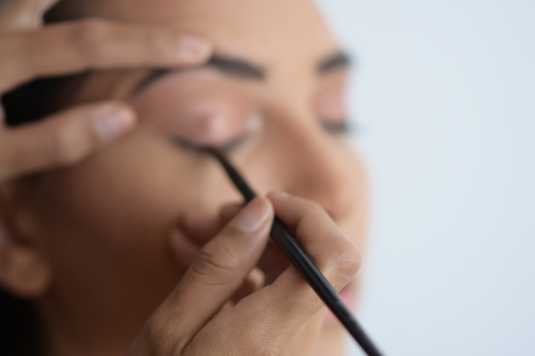 Makeup artist shaping and filling in a client's eyebrows
