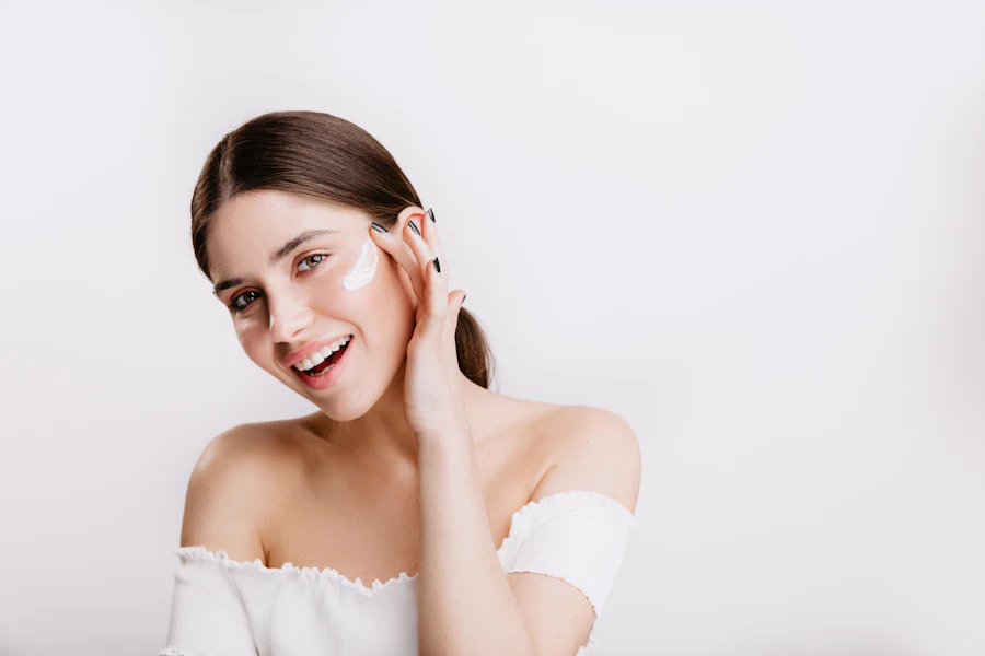 Woman with healthy glowing skin smiling and touching her face