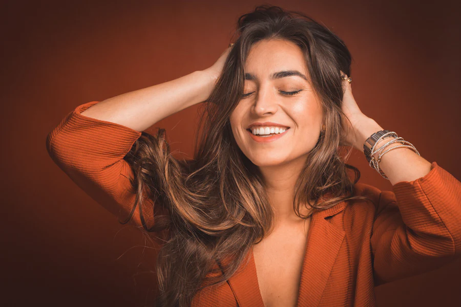 Smiling woman holding her healthy smooth hair