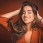 Smiling woman with smooth, shiny hair after a keratin smoothing treatment
