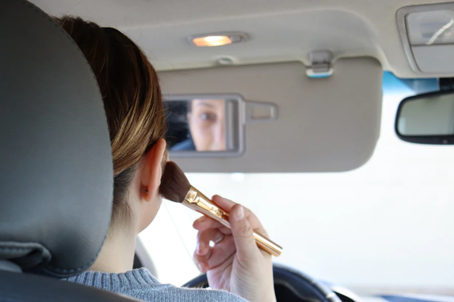 Woman holding a makeup brush while doing her makeup