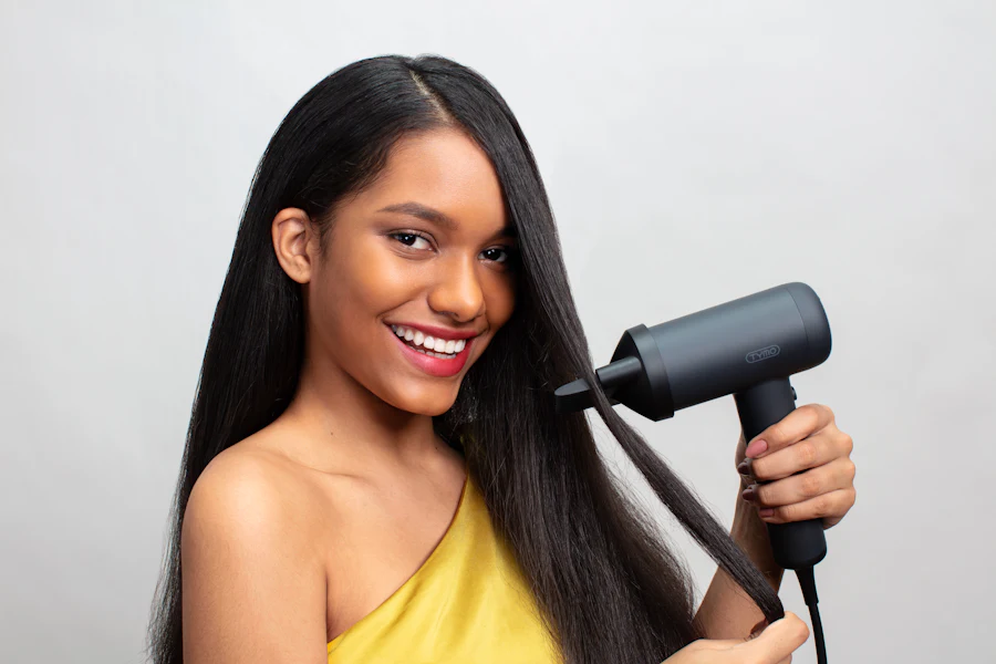 Woman with sleek smooth hair using a hair dryer between keratin touch-ups